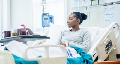 Woman sitting upright on a hospital bed